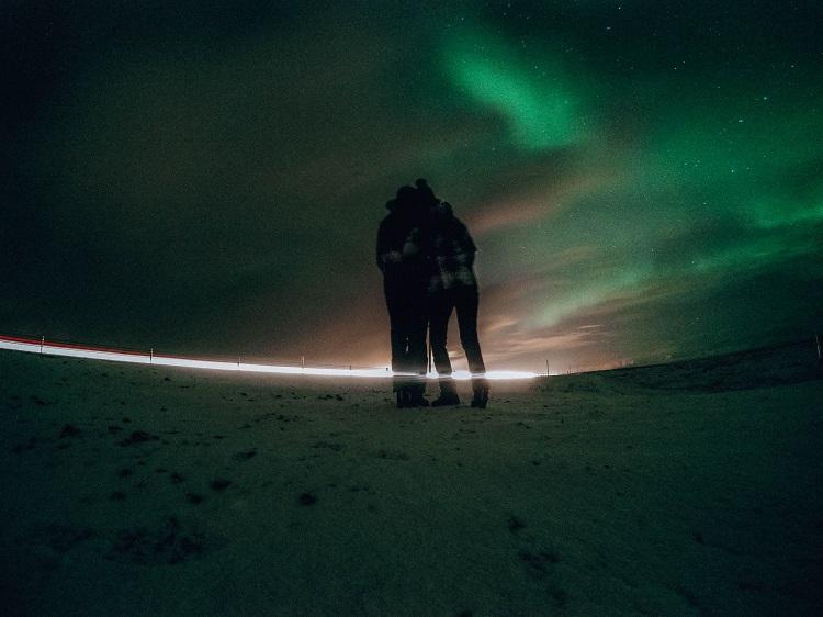 Couple watching the Northern Lights in Iceland during winter