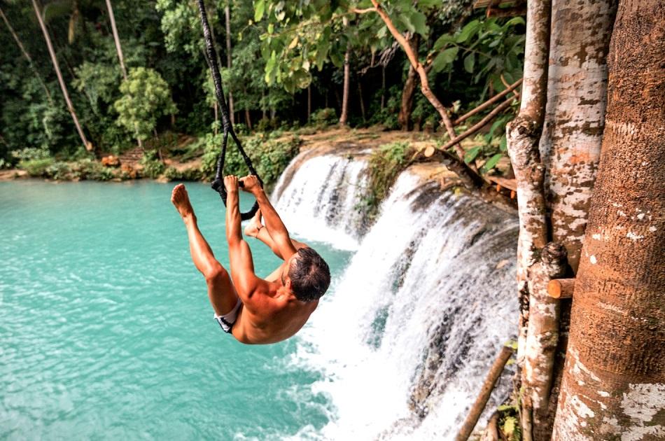 Man on a swing rope at Cambugahay Falls Siquijor