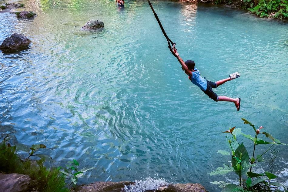 Local swinging at Cambugahay Falls, Siquijor