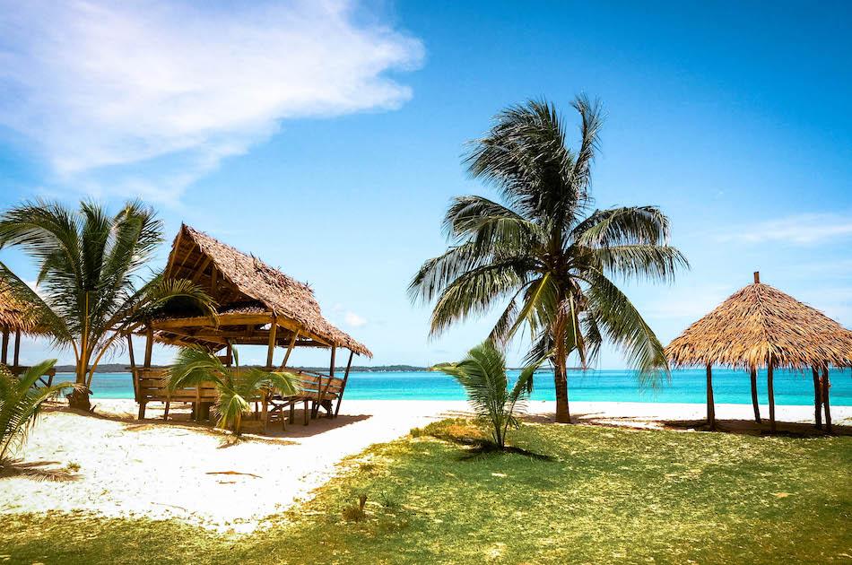 Daku Island Siargao wooden cottages on the beach between palm trees