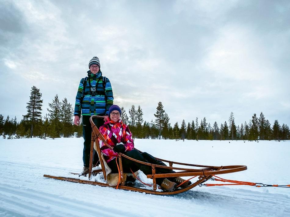 Couple on a sled in snow in Lapland, Finland