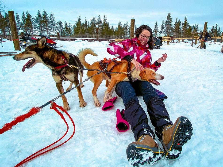 girl playing with sled huskies in Lapland, Finland