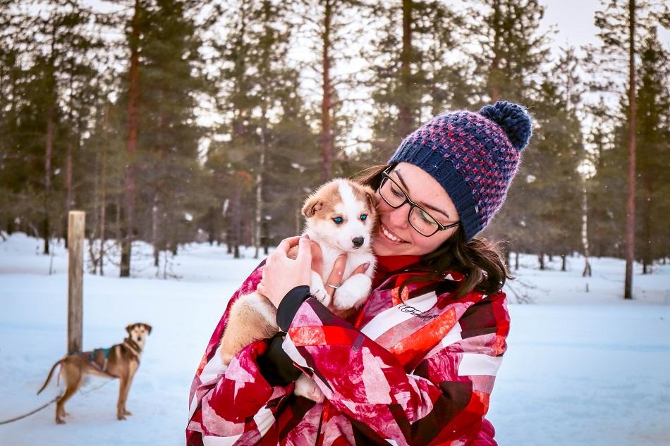 Aurelia Teslaru holding a husky puppy at Kakslauttanen Arctic Resort, Lapland