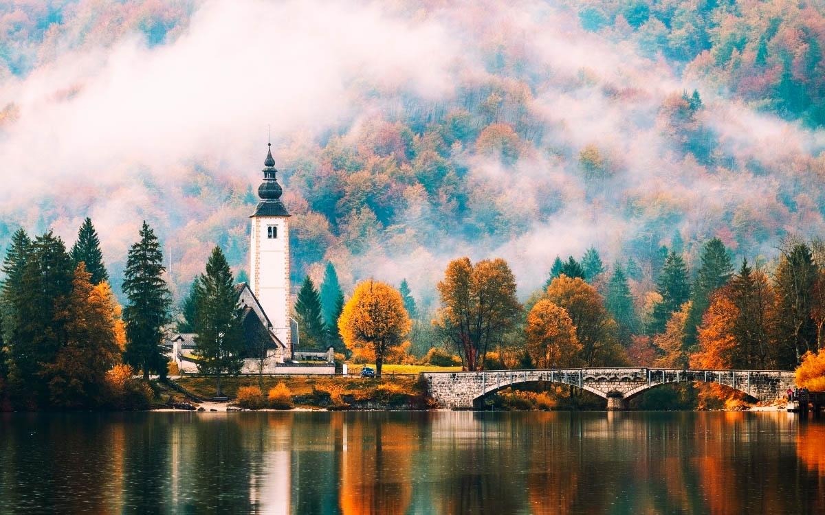 Lake Bohinj Church reflecting into the lake in autumn - hidden gems in Slovenia, off the beaten path, Slovenia off the beaten track, Slovenia secret places, Slovenia unique destinations, less known places in Slovenia