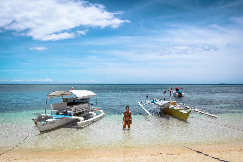 Girl in the water near boats at Paliton Beach Siquijor