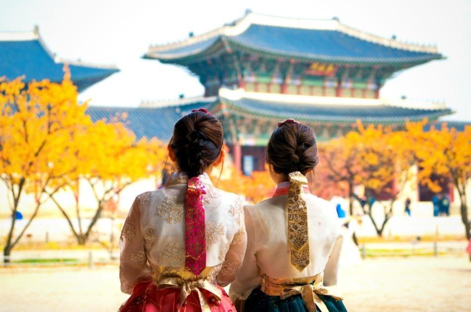 two korean girls dressed in hanbok in front of a palace in Seoul
